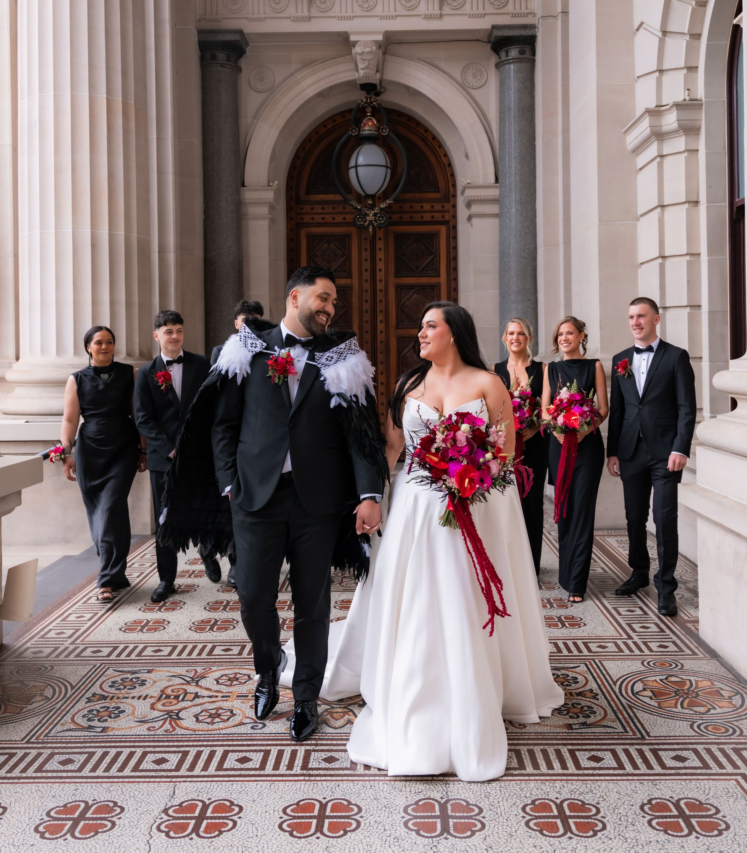 A wedding party walking together beneath Melbourne architecture