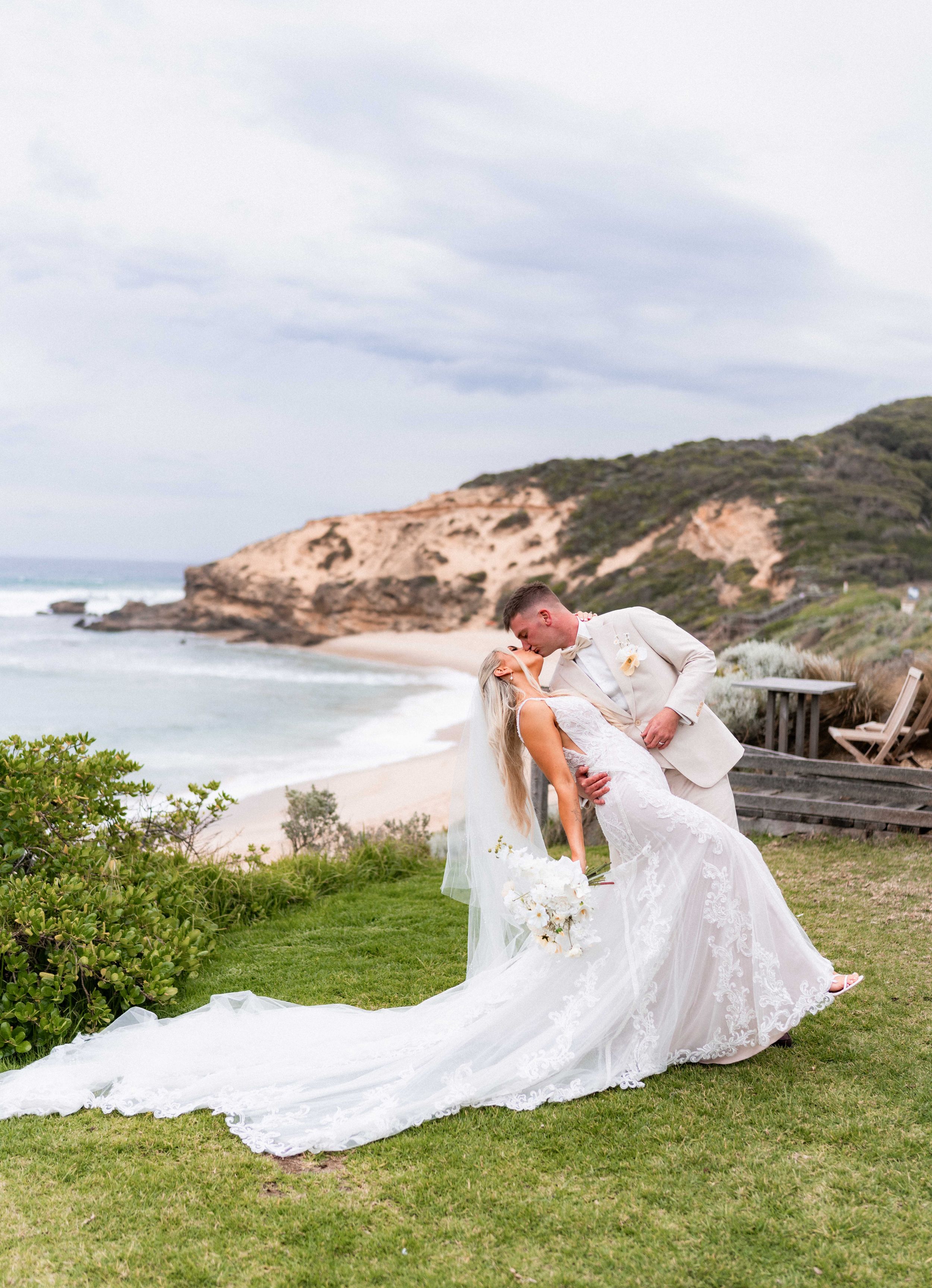 A newlywed couple sharing a quiet moment near the coast